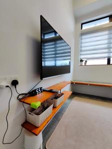 a living room with a desk and a large window at Sunny Nest in Gopeng