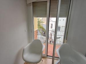 two white chairs sitting in front of a window at Carbo Home y Garaje , Algemesí Home in Algemesí