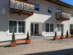 a building with potted plants in front of it at Ferienwohnung Strizi inkl Chiemgau Karte in Ruhpolding