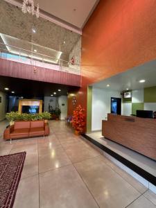 a lobby of a hospital with a couch and flowers at Hotel Tania Searock in Daman