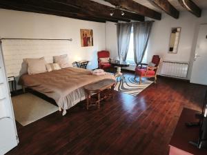 a bedroom with a large bed and chairs in it at La Fée des Greves in Roz-sur-Couesnon