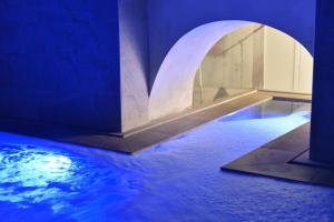 a pool of water in a room with blue lights at Hotel Centrale in Syracuse
