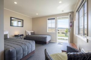 a living room with a couch and a bed and a window at Wedderburn Cottages in Wedderburn