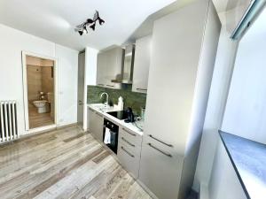a white kitchen with a sink and a toilet at Laglio Cloud Nine, Como Lake in Laglio +3 photos
