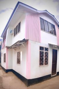 a white building with windows and a door at HANA Transient House in El Nido +4 photos