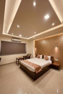 a bedroom with a large bed and a projection screen at Hotel Tania Searock in Daman