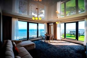 a living room with a couch and views of the ocean at NOYA - Hotel Building Stefan Resort II in Mamaia Sat/Năvodari