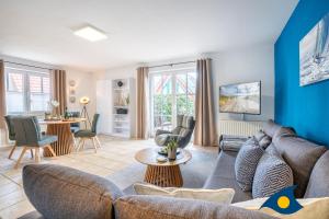a living room with a couch and a table at Fraeulein Loddin Whg_ Willi in Kölpinsee +13 photos