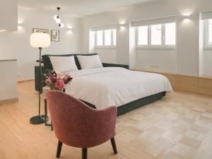 a bedroom with a bed and a chair at LSA Príncipe Real by Numa in Lisbon