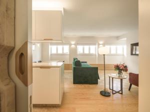 a kitchen and living room with a couch and a table at LSA Príncipe Real by Numa in Lisbon