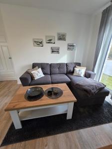 a living room with a couch and a coffee table at Ferienwohnung Möwentöne in Bensersiel