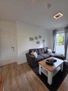 a living room with a couch and a coffee table at Ferienwohnung Möwentöne in Bensersiel