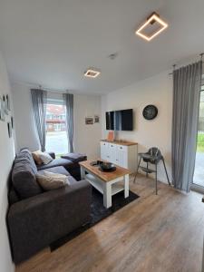 a living room with a couch and a coffee table at Ferienwohnung Möwentöne in Bensersiel