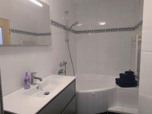 a white bathroom with a sink and a tub at Apartment Alpenblick Lienz in Lienz +3 photos