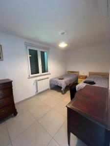 a room with two beds and a dresser and a window at Villa Luigia in Gerenzano