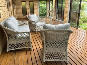 three wicker chairs sitting on a porch at Tarkine Retreat in Penguin