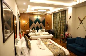a hotel room with two beds and a couch at The Hoften Al Shaykh Resorts, Srinagar in Srinagar +103 photos