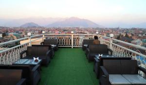 a balcony with chairs and a view of a city at The Hoften Al Shaykh Resorts, Srinagar in Srinagar