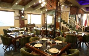 a restaurant with tables and chairs in a room at The Hoften Al Shaykh Resorts, Srinagar in Srinagar