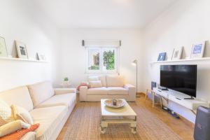 a living room with a couch and a tv at Casa Bettina in Vila Nova de Milfontes
