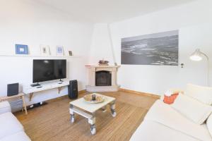 a living room with a couch and a tv and a table at Casa Bettina in Vila Nova de Milfontes +24 photos
