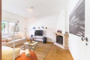 a living room with a couch and a fireplace at Casa Bettina in Vila Nova de Milfontes