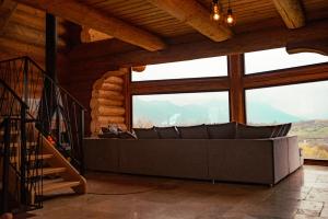 a living room with a couch in front of a large window at Nomad Escape Bran in Sohodol