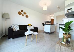 a living room with a couch and a table at L'Échappée Verte - T2 avec balcon in Saulx-les-Chartreux +19 photos