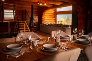 a wooden table with plates and wine glasses on it at Nomad Escape Bran in Sohodol +40 photos