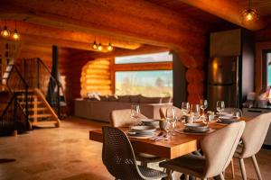 a dining room with a wooden table and chairs at Nomad Escape Bran in Sohodol