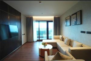 a living room with a couch and a table at Arcor Hotels Mysuru in Mysore