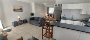 a kitchen and a living room with a couch at Black Rock Haven in Scottburgh