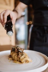 a person is holding a glass dropper over a dessert on a plate at Cosmo Camp in Montepescali