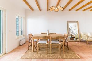 a dining room with a table and chairs and a mirror at Casa Sol Limão in Zambujeira do Mar