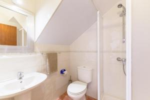 a bathroom with a toilet and a sink and a shower at Casa Sol Limão in Zambujeira do Mar