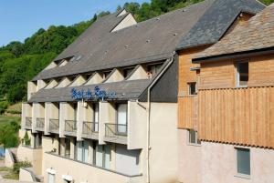 a hotel with a sign on the side of a building at Brit Hotel Du Ban in Chaudes-Aigues