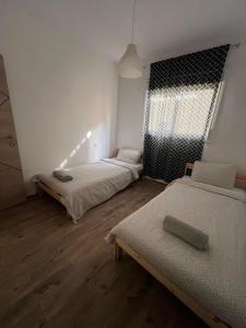 two beds in a small room with wooden floors at Appart Hôtel Signature in Taza