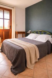 a bedroom with a bed with a blanket on it at La Maison De Stephanie in Porto-Vecchio
