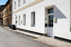 a white building with a door on a street at Symbiola River Apartments in Děčín