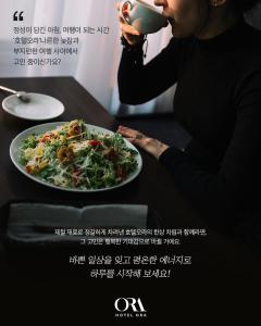 una donna che beve una tazza di tè accanto a un piatto di cibo di Hotel ORA Incheon a Incheon