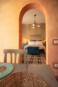a bedroom with a bed and a table and a mirror at Maison de l'Arte di Bà in San Nicola Arcella +35 photos