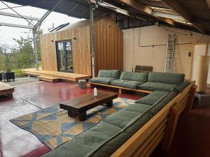 a large living room with green couches and a table at Natuurhuis Bes in Rijssen