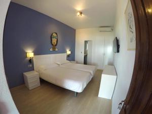 a bedroom with a white bed and a blue wall at Arte Vida in Tarifa +23 photos