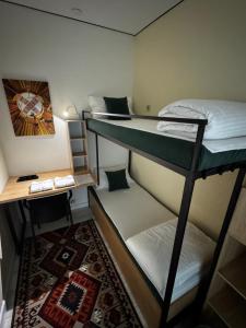 a room with two bunk beds and a desk at Qonys Hostel in Atyrau