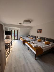 a room with four beds and a table and a desk at SUN & WINE in Pobierowo