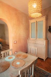 a dining room with a table with chairs and a chandelier at Maison de l'Arte di Bà in San Nicola Arcella