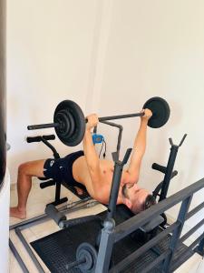 a man laying on a reformer with weights at Ceylon Pearlwing Resort in Negombo