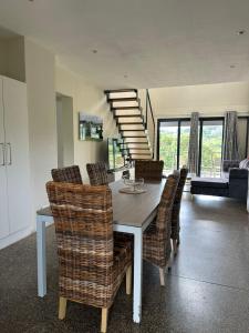 a dining room with a table and chairs and a staircase at Apartments on The Eighteenth at Prince's Grant Golf Estate in Blythedale