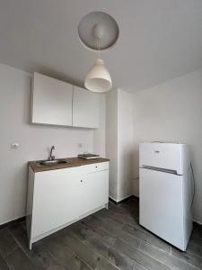 a kitchen with a sink and a refrigerator at Appart Hôtel Signature in Taza
