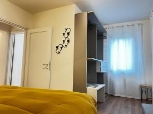 a bedroom with a yellow bed and a window at Casa Primavera in Agordo
